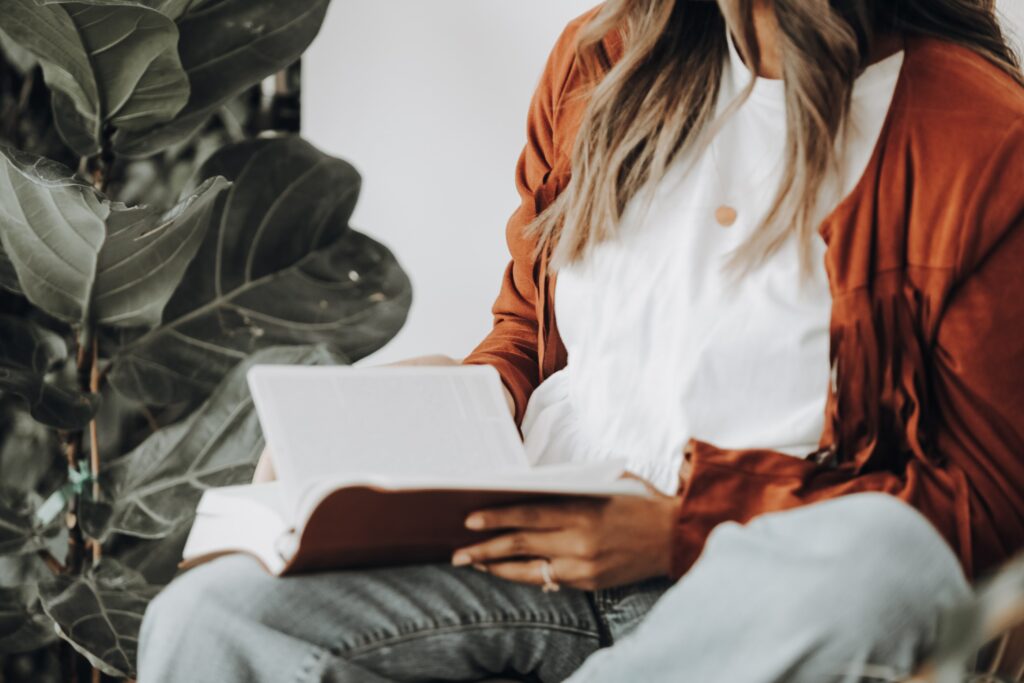 Photo of a woman reading a book; this photo is a part of the Aspireship Success Story blog post about pandemic career changes into SaaS sales; Aspireship provides free SaaS sales training and job placement help. 