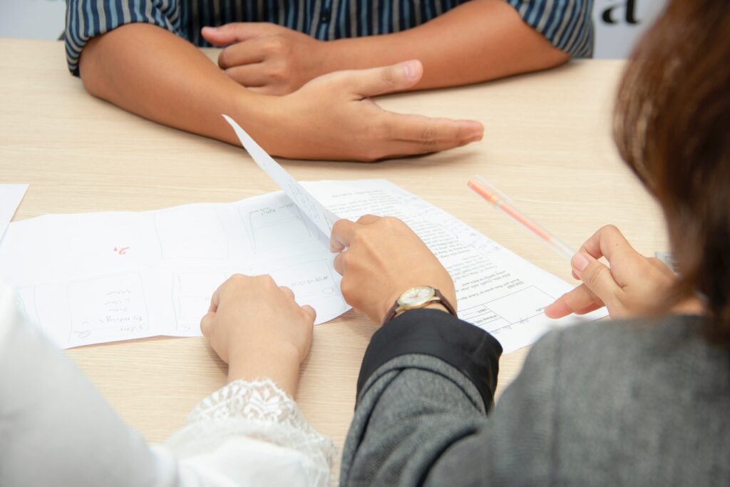 Photo of a job recruiter looking at a resume during a job interview; many individuals have found themselves at a career crossroads as a result of the pandemic and this blog post explores Alexandra's Aspireship Success Story; Aspireship provides free SaaS sales training and job placement to graduates.